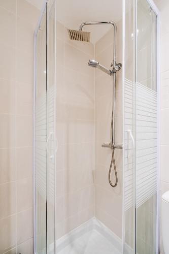 une douche avec une porte vitrée dans une salle de bain dans l'établissement Douce Escale à La Cité, à Carcassonne