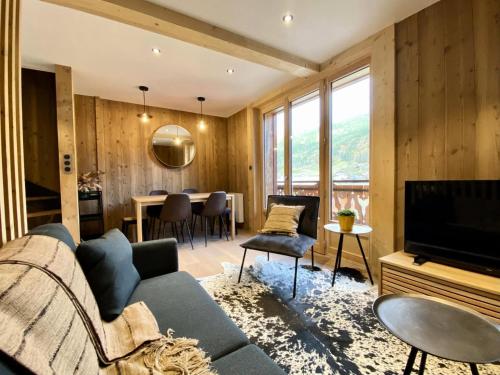 un salon avec un canapé et une télévision dans l'établissement Résidence Le Soleil Levant - Appartement Loulou - 4 personnes - Morzine centre MAE-4051, à Morzine