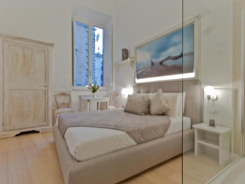 a bedroom with a bed and a painting on the wall at Primo Piano Suites in Rome