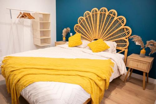 a bedroom with a large bed with a yellow blanket at Villa La Perle Bleue in Ebersheim