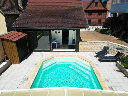 a swimming pool in front of a house at Villa La Perle Bleue in Ebersheim
