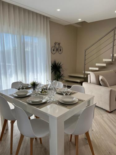 a white dining room table and chairs in a living room at Casa Perla dell'Etna in Ragalna