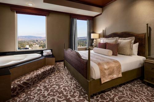 a bedroom with a bed and a tub and a window at Silver Legacy Reno, A Caesars Destination in Reno