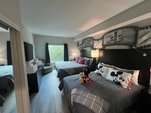 1 dormitorio con 2 camas con animales de peluche en Disneyshuttleking & Queen Be 5 Minutes To Disney, en Orlando