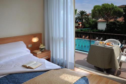 a bedroom with a bed and a balcony with a table at Raffy Family & Bike Hotel in Diano Marina