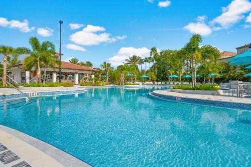 a swimming pool at a resort with palm trees at Resort Townhome: Perfect Orlando Vacation Spot in Orlando