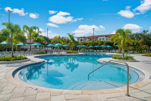 a pool at a resort with palm trees and umbrellas at Majestic Holiday in Orlando