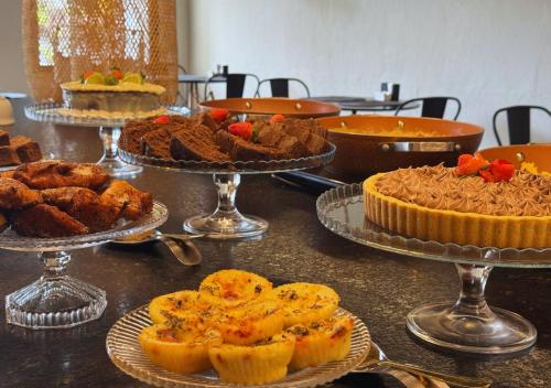 a table topped with pies and other desserts on plates at Nord One in João Pessoa