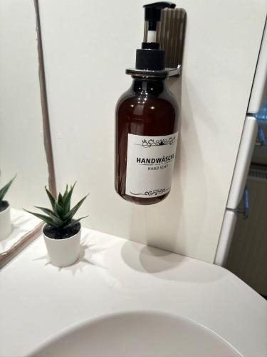 a bottle of honey on a wall next to a toilet at Pension FAULPELZ - Budget Apartment mit Küche, Badewanne in Niederorschel