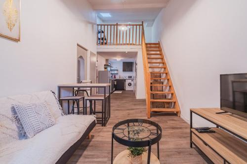 un salon avec un canapé et une télévision dans l'établissement La Petite Bastide, à Carcassonne