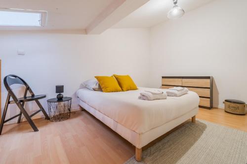 une chambre avec un lit avec des oreillers jaunes dessus dans l'établissement La Petite Bastide, à Carcassonne