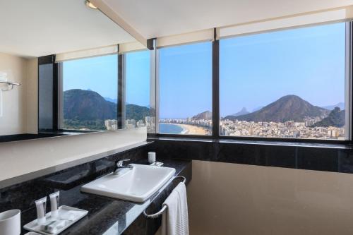 a bathroom with a sink and large windows at Hilton Copacabana Rio de Janeiro in Rio de Janeiro