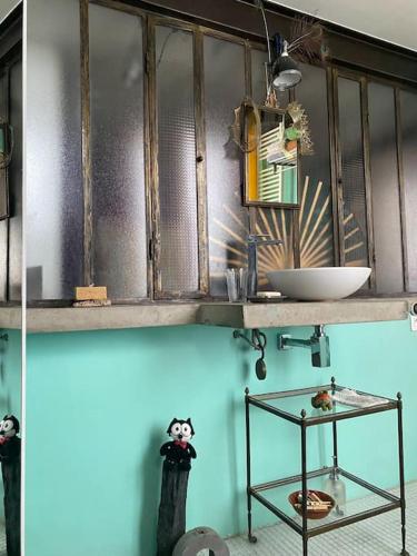 La salle de bains est pourvue d'une étagère avec un lavabo et un bol. dans l'établissement Logement de charme type loft parisien, à Bagnolet