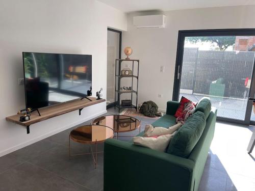 a living room with a green couch and a large window at Magnifique villa avec jacuzzi in Bourgheim