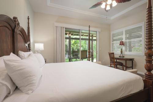 Un dormitorio con una gran cama blanca y una ventana. en Fairways at Mauna Lani 1405 Garden View 3B 2 and half Bath, en Waikoloa