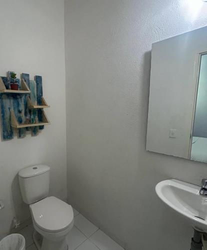 a white bathroom with a toilet and a sink at Zana Hotel Boutique in Bogotá