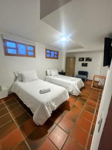 two beds in a room with a tiled floor at Zana Hotel Boutique in Bogotá