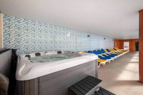 a jacuzzi tub in a room with chairs at Hotel Colmeia in Monte Real