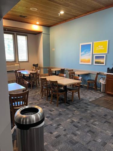 una sala da pranzo con tavoli, sedie e un cestino di Days Inn by Wyndham Hutchinson a Hutchinson