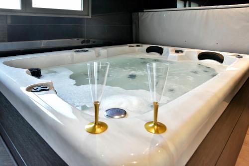 una bañera con dos copas de vino. en Cocöon Rance, en Plouër-sur-Rance