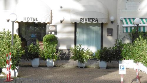 a hotel with potted plants in front of a building at Hotel Riviera in Arenzano