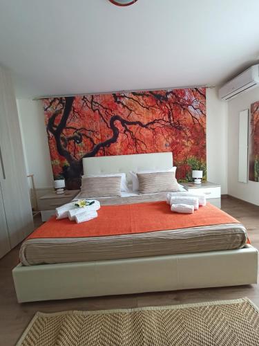 a bedroom with a large bed with a painting on the wall at La Petite Maison in Aci Castello