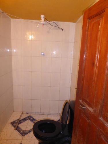 a bathroom with a toilet with a black toilet seat at Hostal Amanecer in Comunidad Yumani