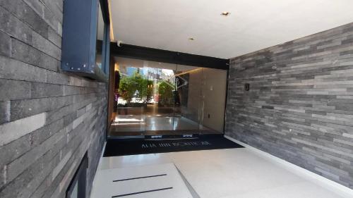 a room with a brick wall and a television at Alia Inn Boutique WTC in Mexico City