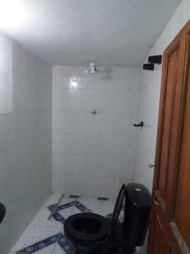 a bathroom with a toilet and a tiled floor at Hostal Amanecer in Comunidad Yumani