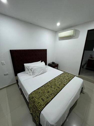 a bedroom with a large white bed in a room at Hotel Ipanema Meridian in Neiva