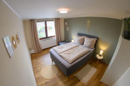 una piccola camera da letto con un letto e una finestra di 4 Sterne FeWo Rhönland-Erlebnis in Bernshausen - auch für Wanderreiter a Bernshausen