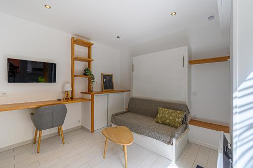 un salon avec un canapé et une chaise dans l'établissement Studio proche Centre Ville, à Quimper