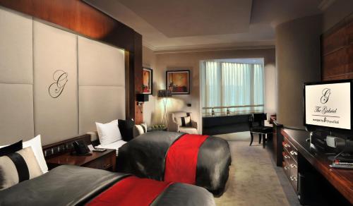 a hotel room with two beds and a flat screen tv at Sun City Hotel - The Gabriel in Cairo