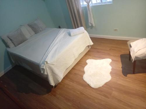 a bedroom with a bed and a rug on the floor at Chandler Homestay in Saint Philip
