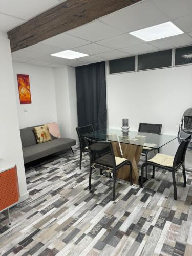 a meeting room with a glass table and chairs at Arhomeplus-hunic in Autun