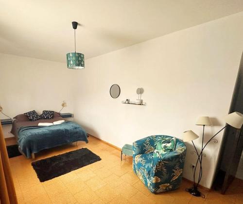 a bedroom with a bed and a chair at Casa do Cruzeiro - Favaios in Favaios