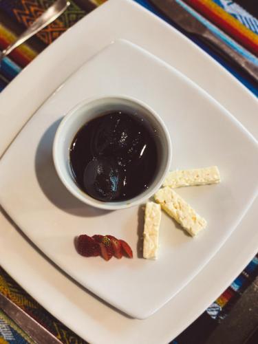 a plate with a cup of dipping sauce and crackers at Hotel El Abrazo del Arbol in Mindo