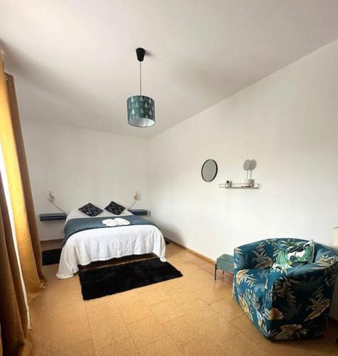 a bedroom with a bed and a chair at Casa do Cruzeiro - Favaios in Favaios