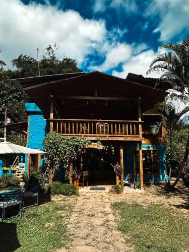 a blue building with a large roof at Hotel El Abrazo del Arbol in Mindo
