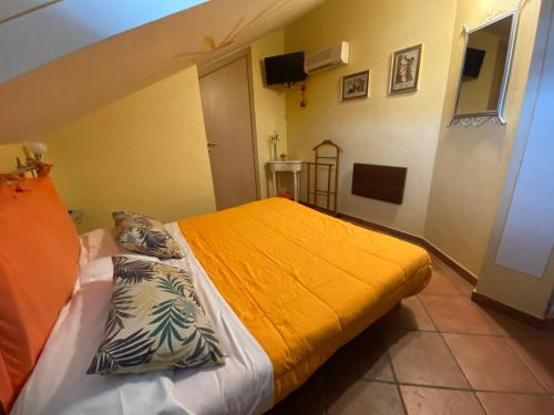 a bedroom with a bed with an orange blanket at B&B Torre in Langa in Carrù