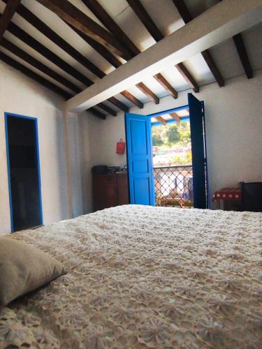 a bedroom with a bed and a blue door at Patio Chic in Jericó