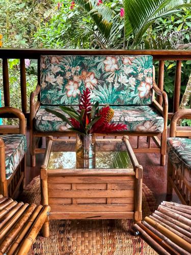 a couch and a coffee table on a porch at Hotel El Abrazo del Arbol in Mindo