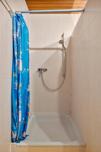 a shower with a blue shower curtain in a bathroom at Familyhouse Cologne in Hürth