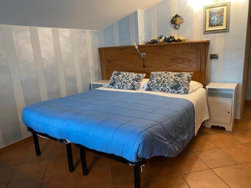 a bedroom with a bed with blue sheets and pillows at B&B Torre in Langa in Carrù