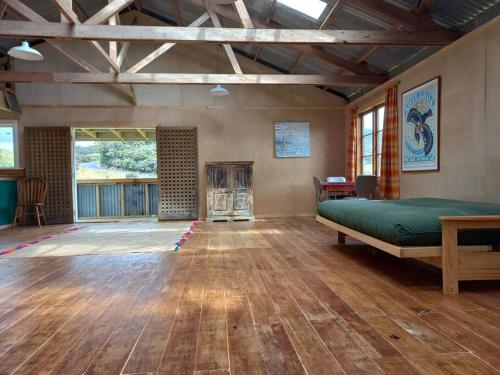 a large room with a bed and a fireplace at The Woolshed, Papa Aroha, Coromandel in Moturua Island