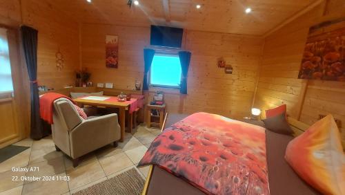 a bedroom with a bed and a table in a room at Pfalz-Apartment Mein Chalet - Einzigartig in Großkarlbach in Großkarlbach
