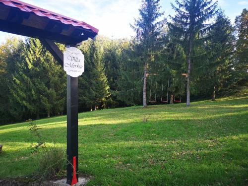 a sign on a pole in a grass field at Kuća za odmor "Villa Merkur" - Orahovica in Orahovica