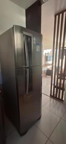 a stainless steel refrigerator sitting on a tile floor at Ap 2 quartos tipo resort pé na areia 1 in Barra dos Coqueiros