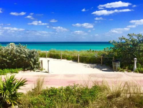 a path to the beach with the ocean in the background at 3 Bedroom 3 Bathroom Miami Beach Apartment in Miami Beach