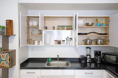 a kitchen with white cabinets and a sink at 3 Bedroom 3 Bathroom Miami Beach Apartment in Miami Beach